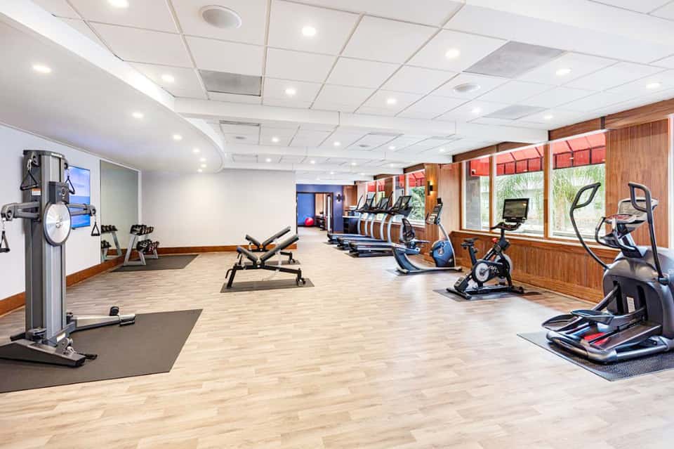 Spacious fitness center with cardio equipment, exercise bikes, and wooden accents throughout