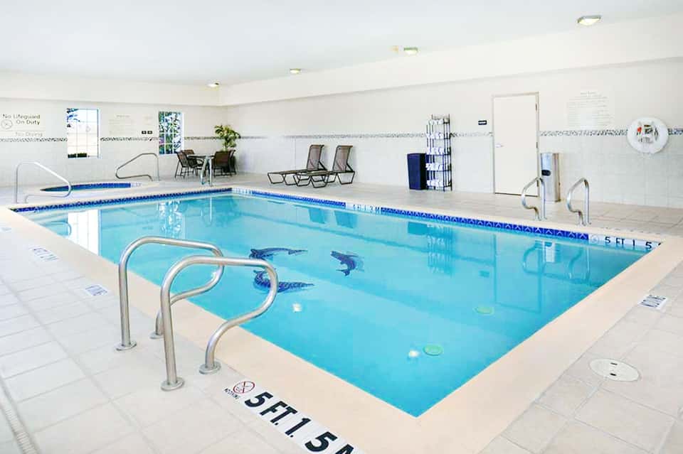 Indoor Olympic-size lap pool with bright white walls and seating area