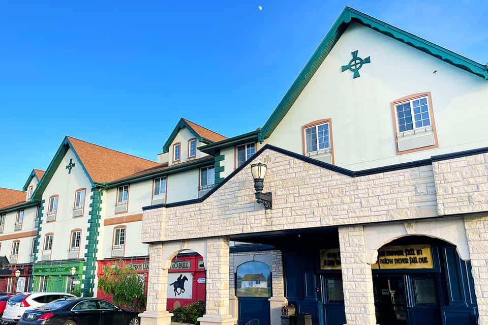 Charming Irish-style hotel exterior with white walls, green roof, and red doors