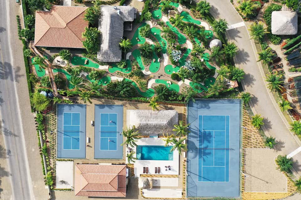 Aerial view of resort with pools, mini golf course, and manicured grounds
