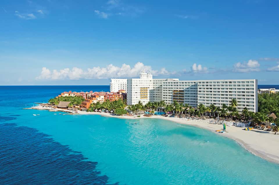 Turquoise Caribbean beach with resort buildings, white sand, and clear water in Cancun