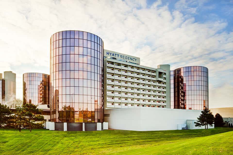 Hyatt Regency hotel with distinctive cylindrical glass towers and manicured lawn