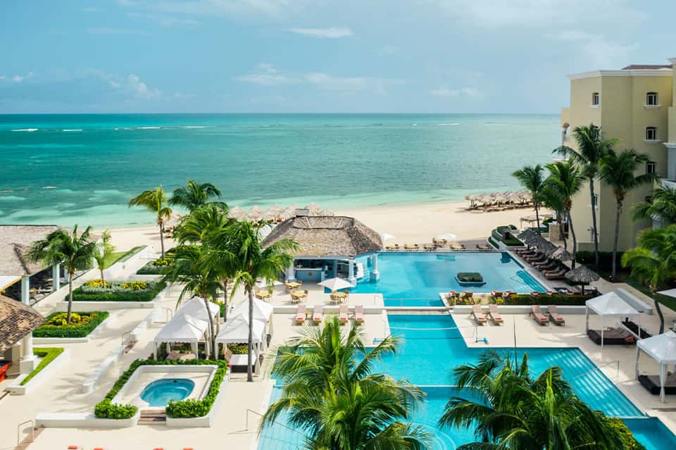 Luxury beachfront resort with cascading pools overlooking turquoise ocean