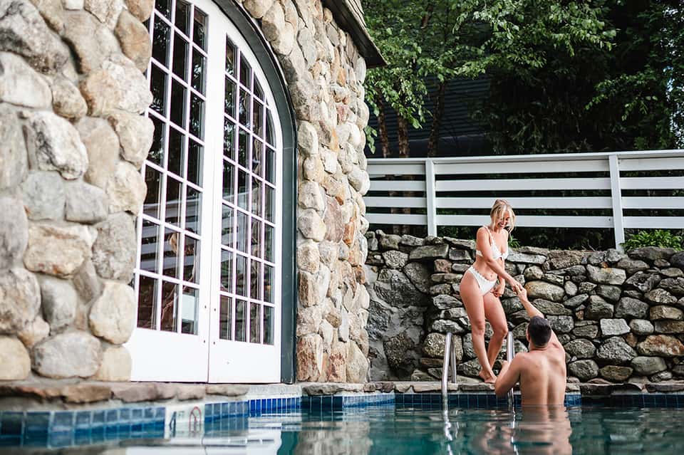 Stone cottage pool house with couple relaxing in small private swimming pool