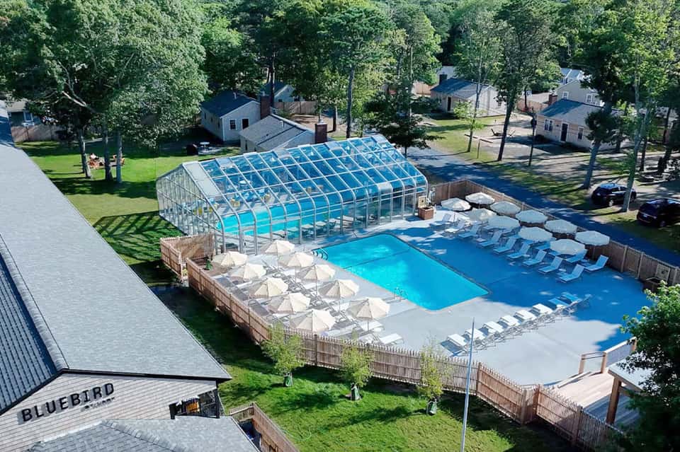 Aerial view of covered indoor pool complex with lounge chairs and surrounding grounds