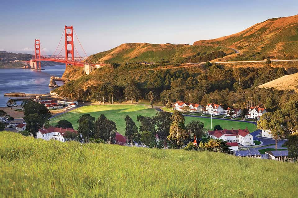 Golden Gate Bridge landscape with coastal homes and rolling green hills