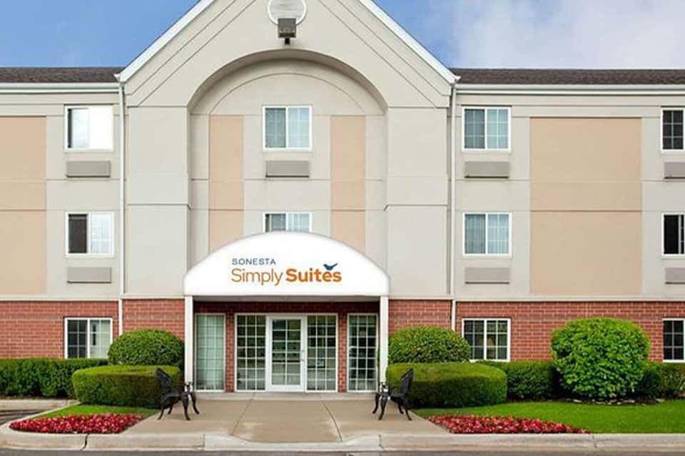 Sonesta Simply Suites hotel exterior with brick facade and landscaped entrance