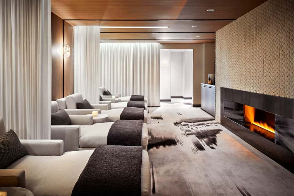 Luxury home theater with curved seating, fireplace, and neutral tones