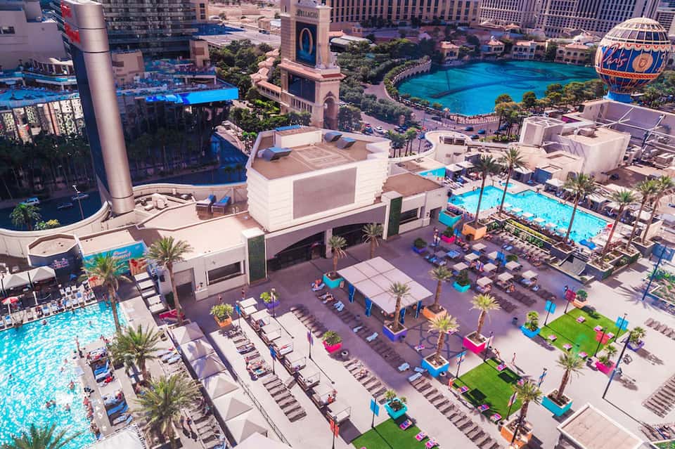 Aerial view of luxury resort with turquoise pools, palm trees, and high-rise hotels in Las Vegas
