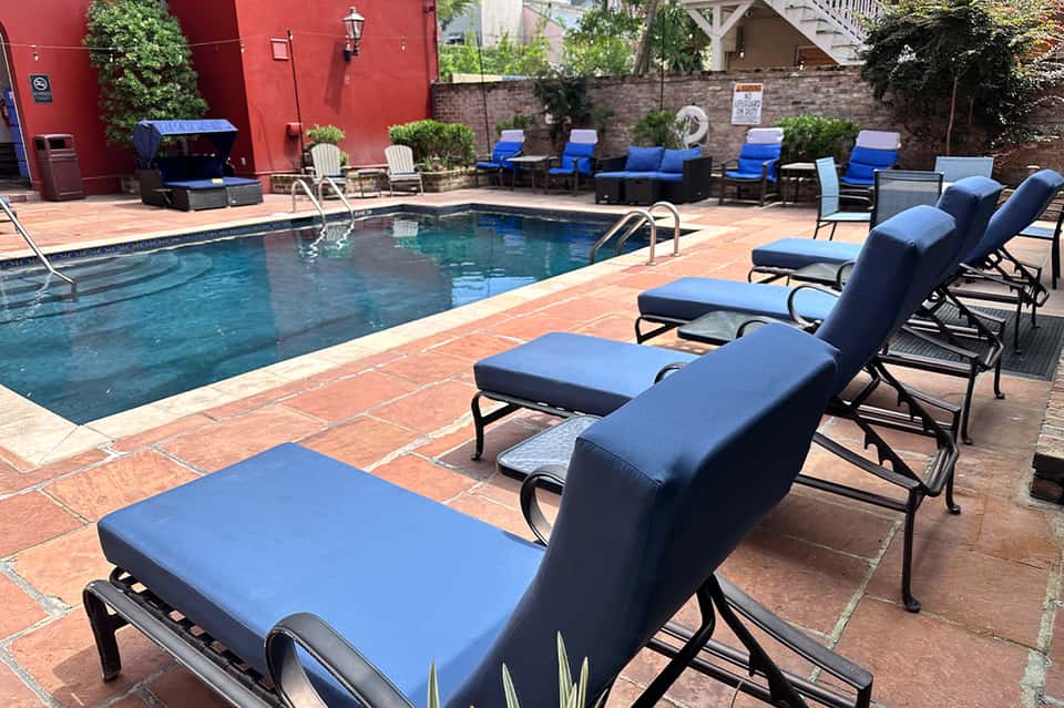 Resort pool deck with blue lounge chairs and red brick patio