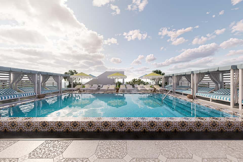 Resort pool with cabanas and lounge chairs under blue sky with fluffy clouds