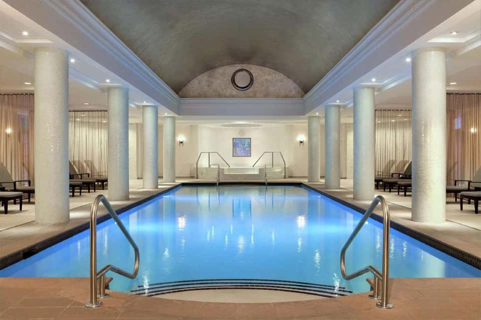 Indoor lap pool with marble columns and elegant classical design
