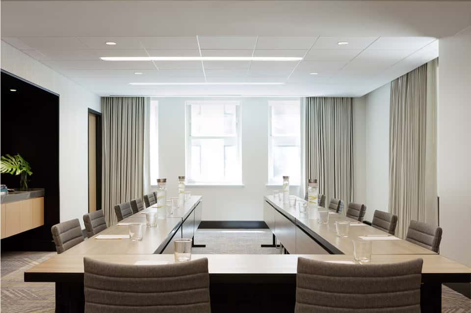 Corporate meeting room with U-shaped table setup and floor-to-ceiling windows