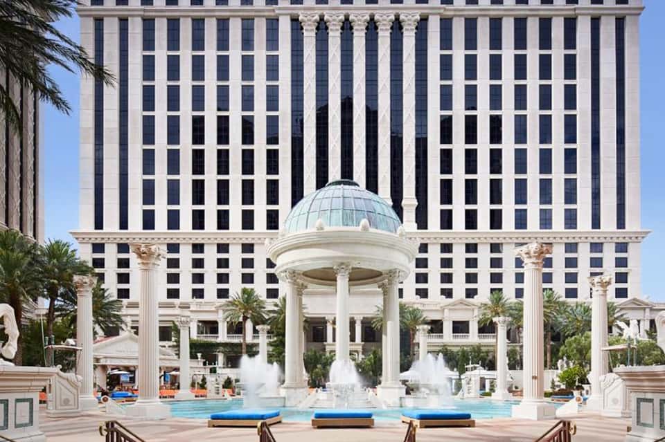 Luxury resort courtyard with classical dome structure, fountains, palm trees, and columned architecture