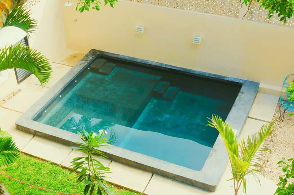 Aerial view of small rectangular pool in courtyard surrounded by tropical plants