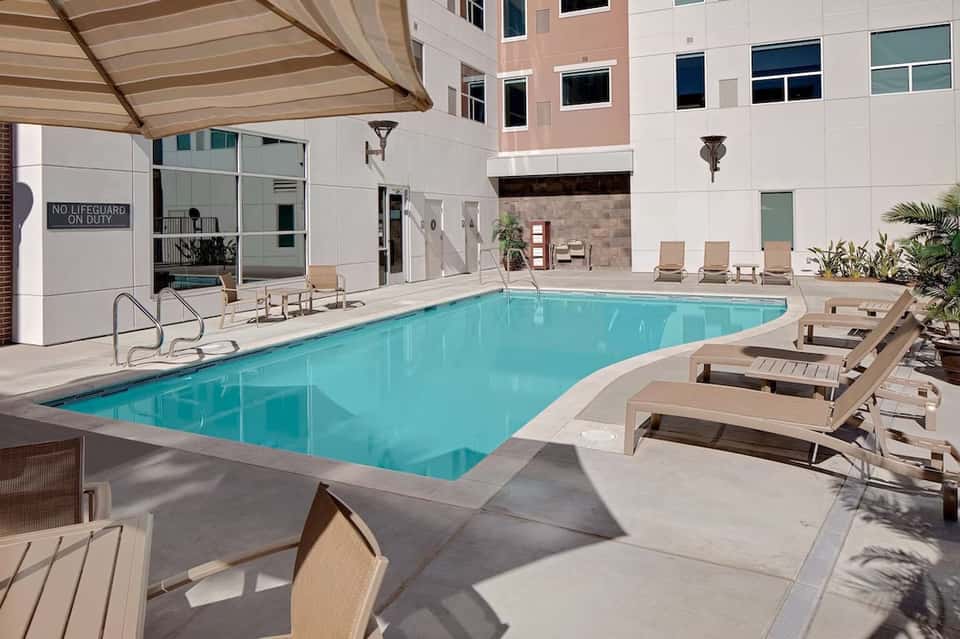 Rectangular indoor pool with beige lounge chairs and contemporary hotel architecture