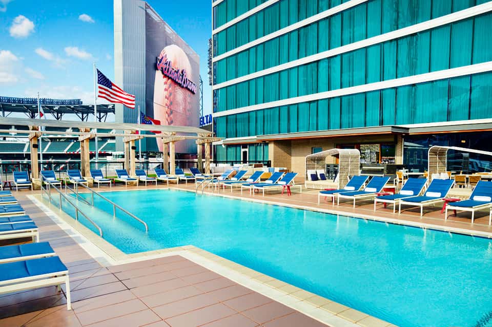 Urban rooftop pool with blue loungers and high-rise buildings