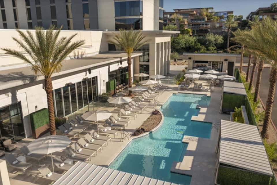 Resort courtyard aerial view with lagoon-style pool, lounge chairs, and palms