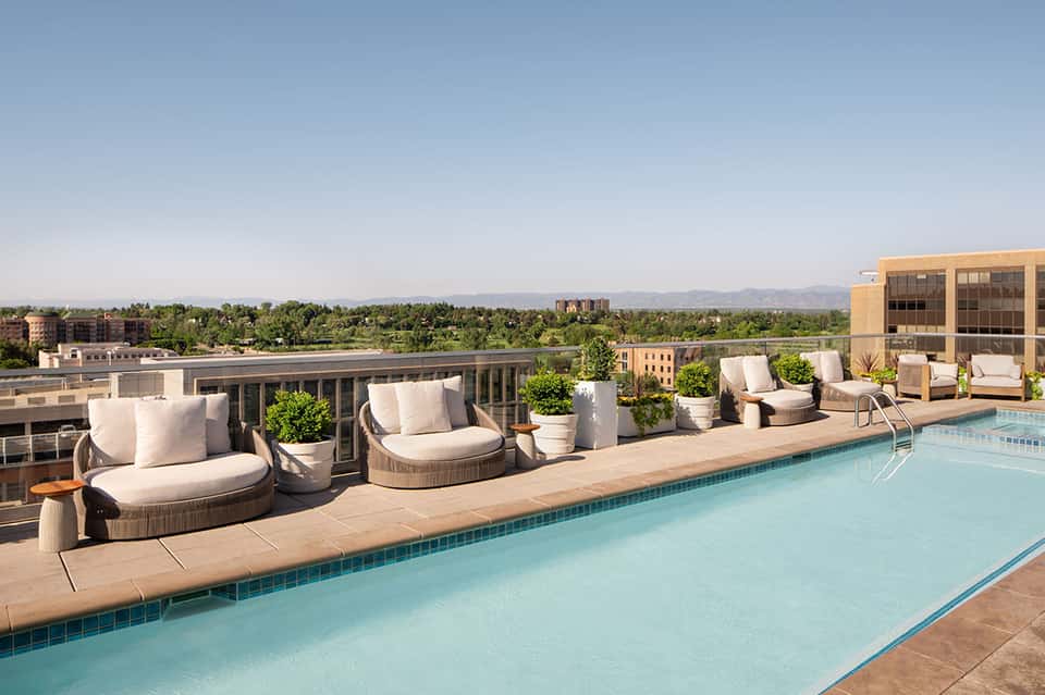 Rooftop pool with city skyline views, lounge seating, and modern architectural design