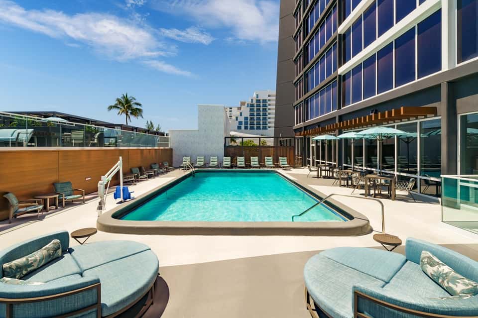 Rooftop pool at urban hotel with lounge chairs and city skyline views