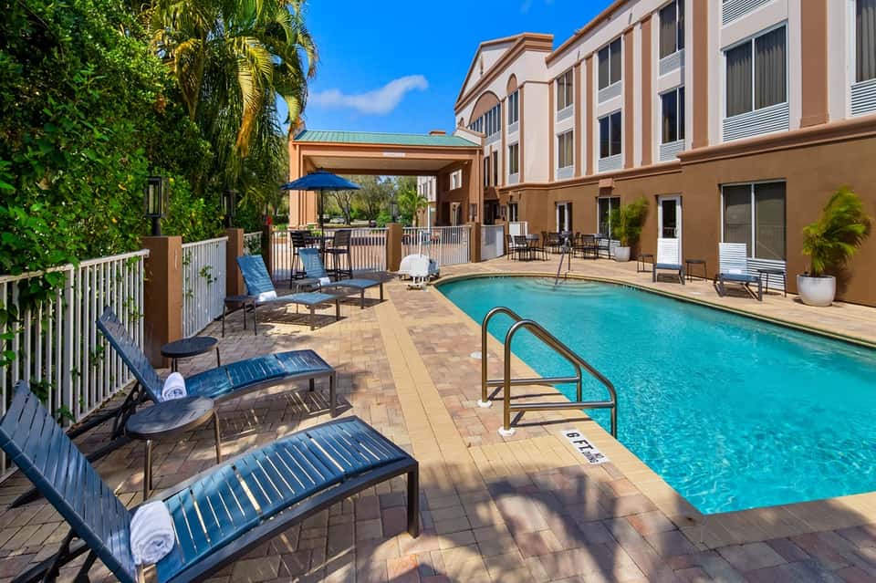 Hotel courtyard pool with lounge chairs and multi-story building