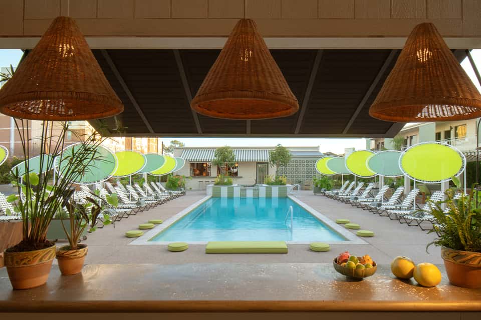 Indoor resort pool with lime green umbrellas and woven cone light fixtures