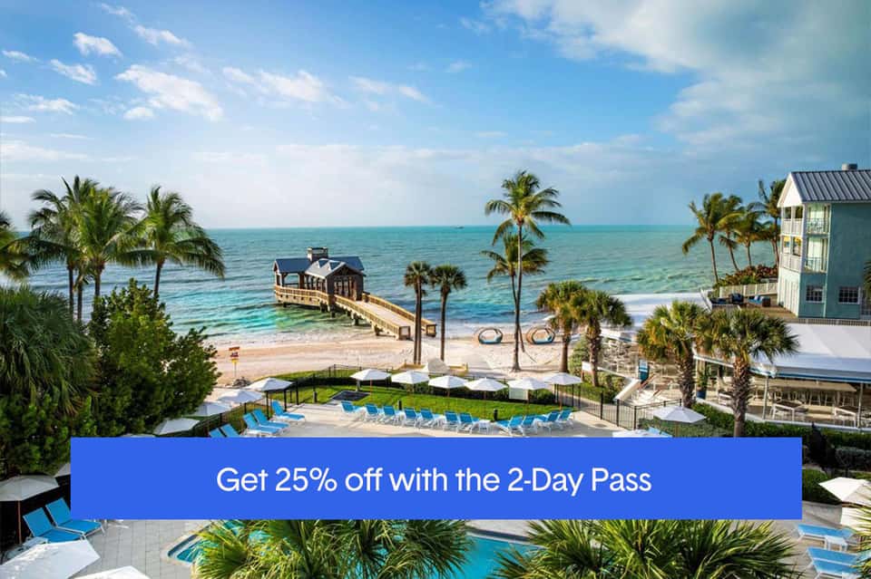 Beachfront resort with pier, pools, palm trees, and turquoise ocean waters