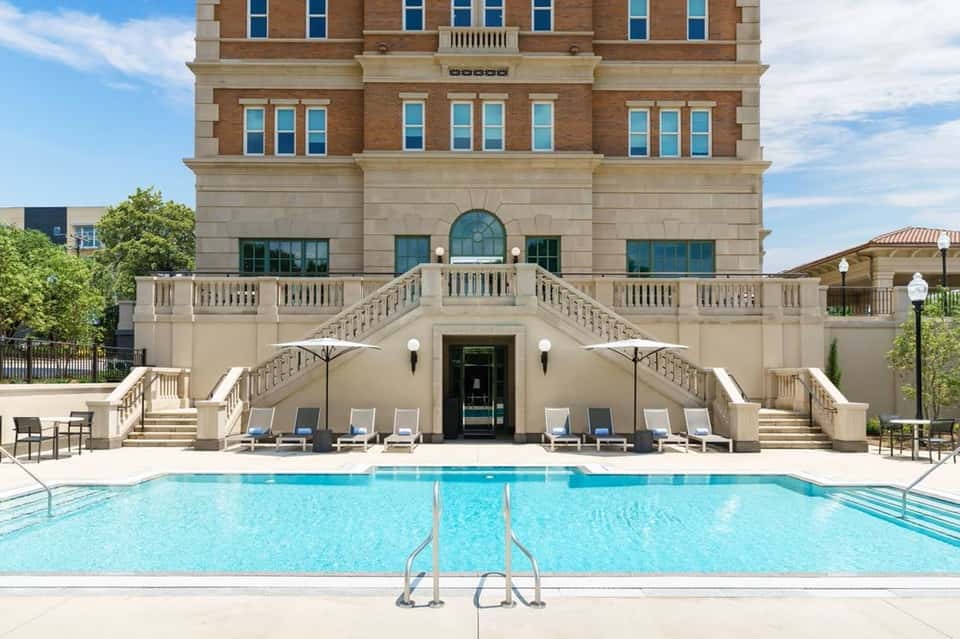 Grand resort pool with classical architecture and chaise lounges