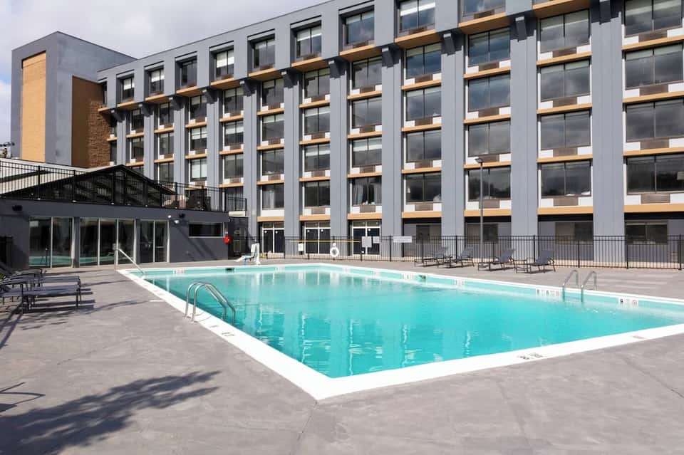 Resort outdoor swimming pool with modern multi-story hotel building behind it
