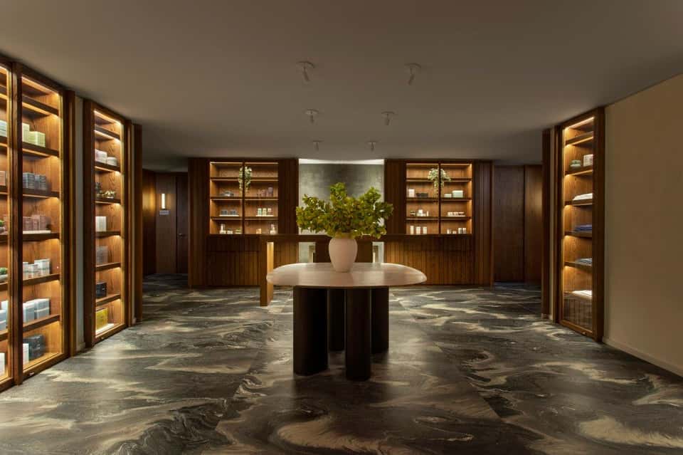 Upscale spa retail space with illuminated wooden shelving and central display table