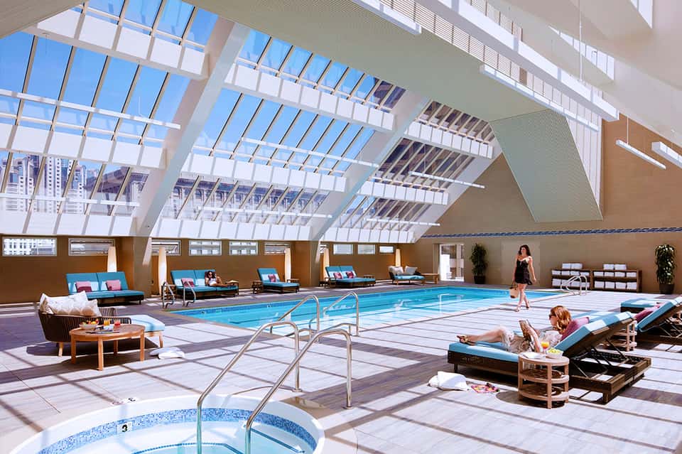 Modern indoor pool facility with skylights and lounge seating