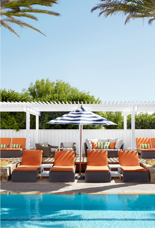 A refreshing pool surrounded by comfortable lounge chairs and shaded umbrellas.