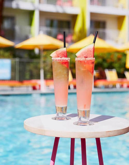 Tropical drinks set on a table at a hotel's pool deck