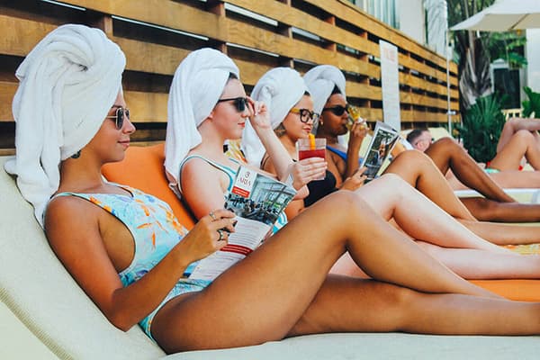 Women lounging by the pool at a hotel