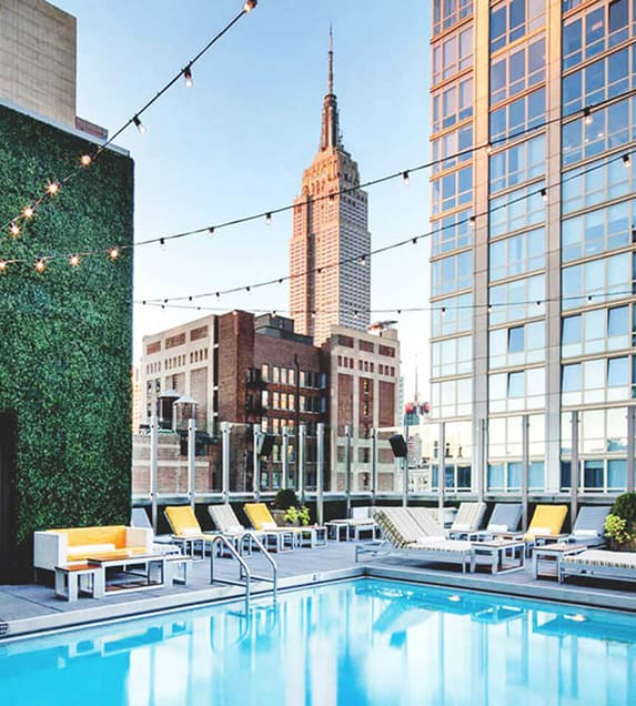 A hotel with a rooftop pool and view of the city
